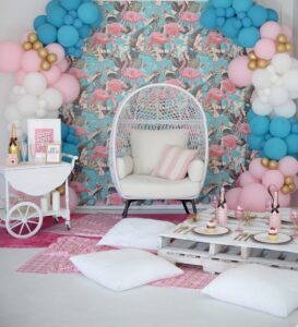 Chic indoor photo studio with flamingo wallpaper and balloon decorations.