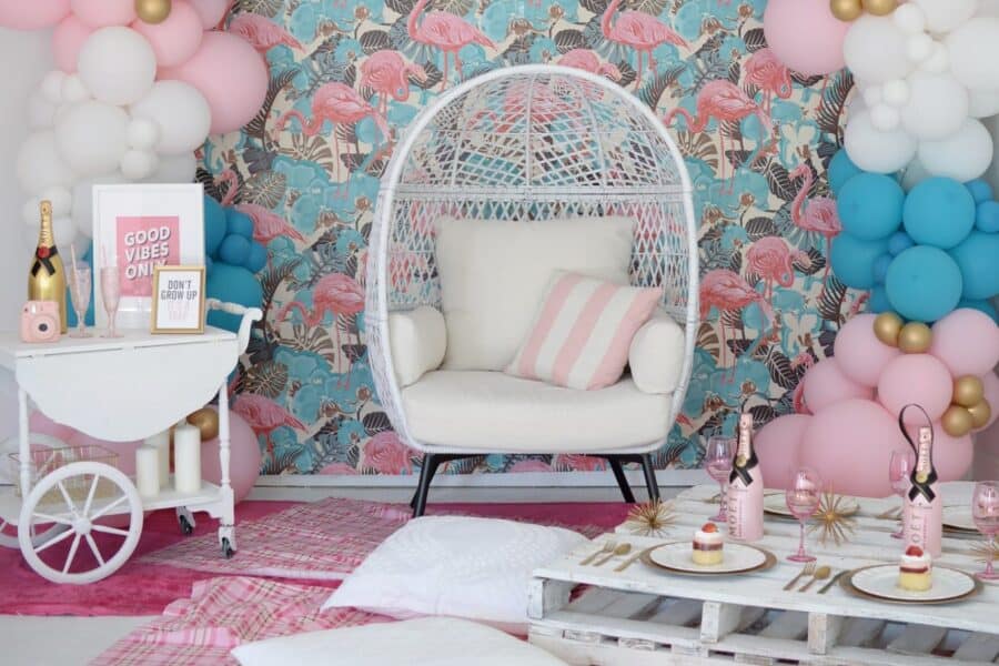 Chic indoor photo studio with flamingo wallpaper and balloon decorations.