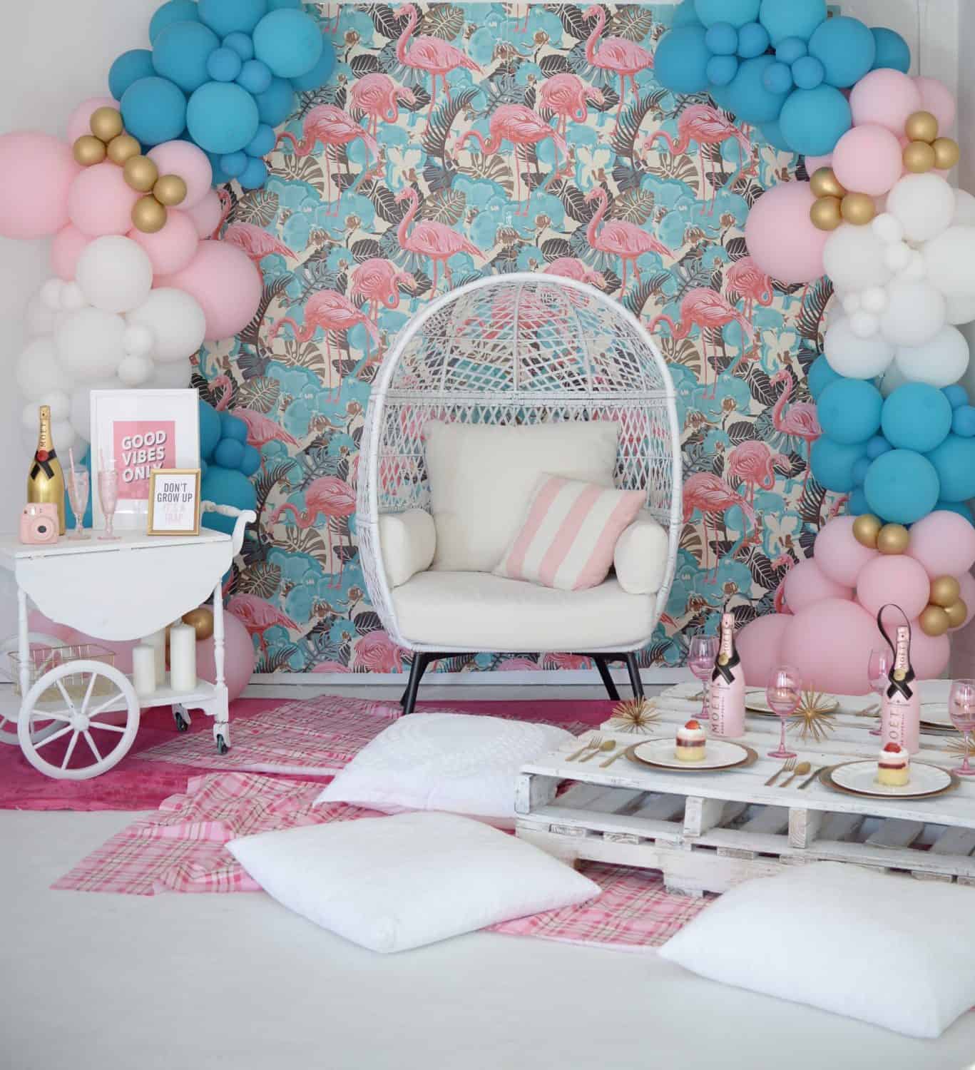 Chic indoor photo studio with flamingo wallpaper and balloon decorations.