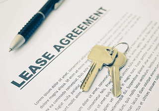 Lease agreement document with a set of keys on top, representing office rental agreement.