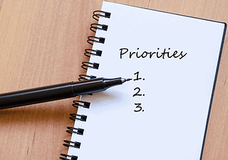 Notebook with priorities list and pen for office space planning.