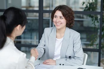 Two women shaking hands during a business meeting at The Focal Point Group office.