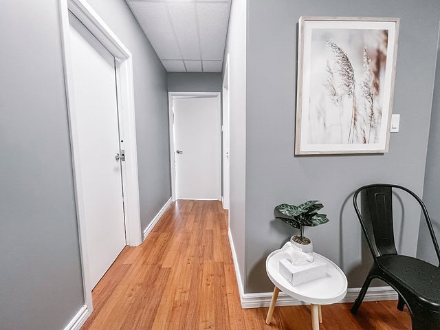 Interior view of office hallway with artwork and seating area.