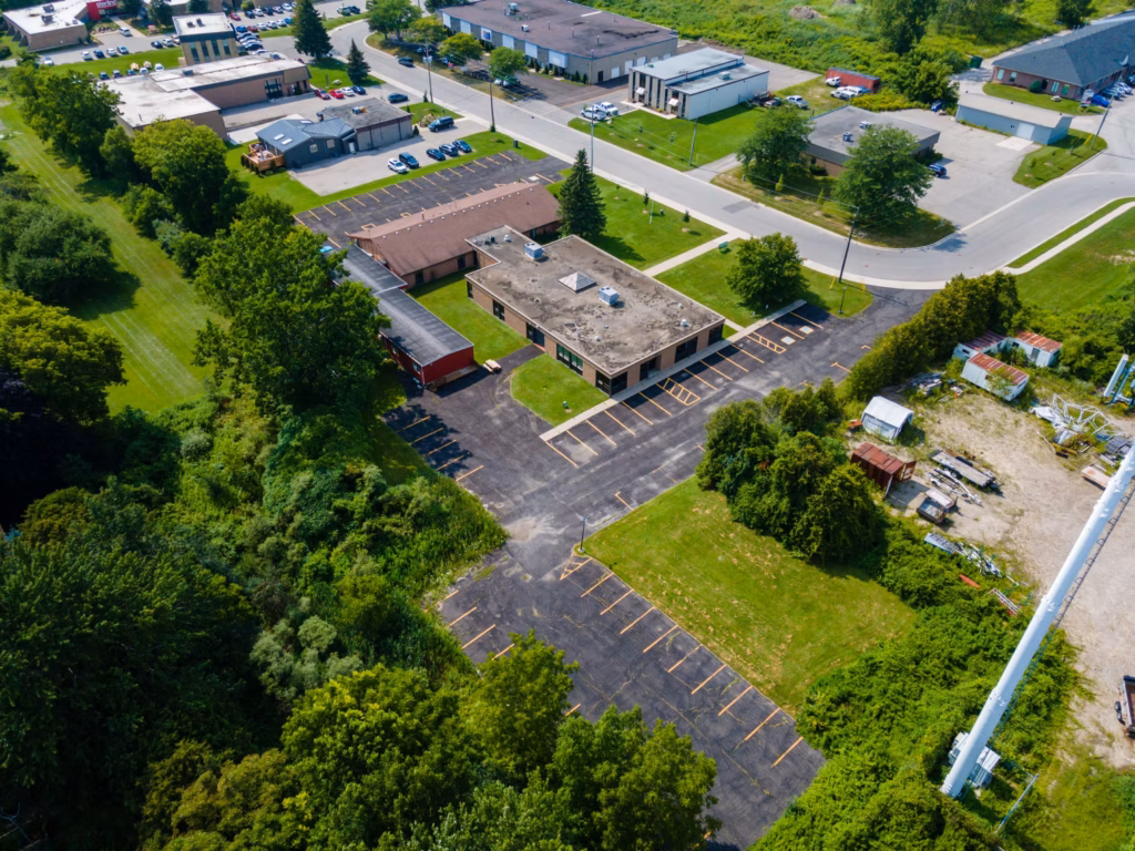 Aerial view of an industrial park with buildings, parking lots, roads, and green spaces.