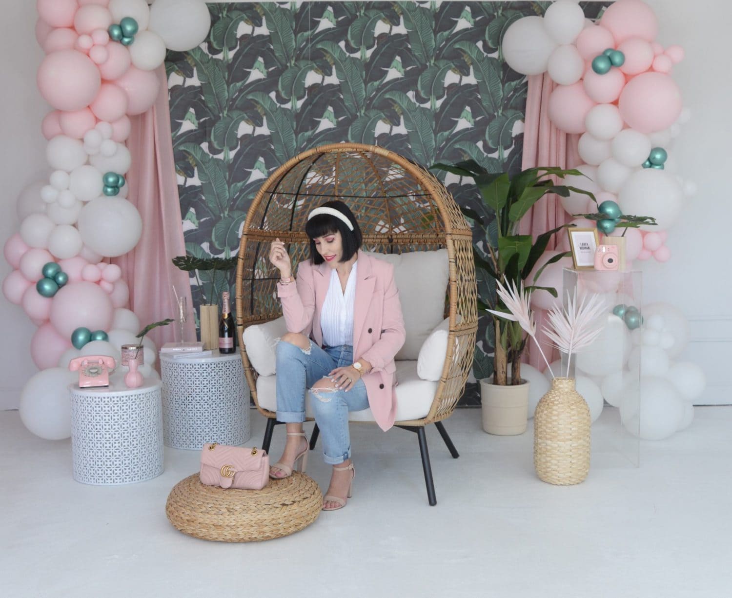 Woman relaxing in a stylish, colorful workspace with balloons and plants.