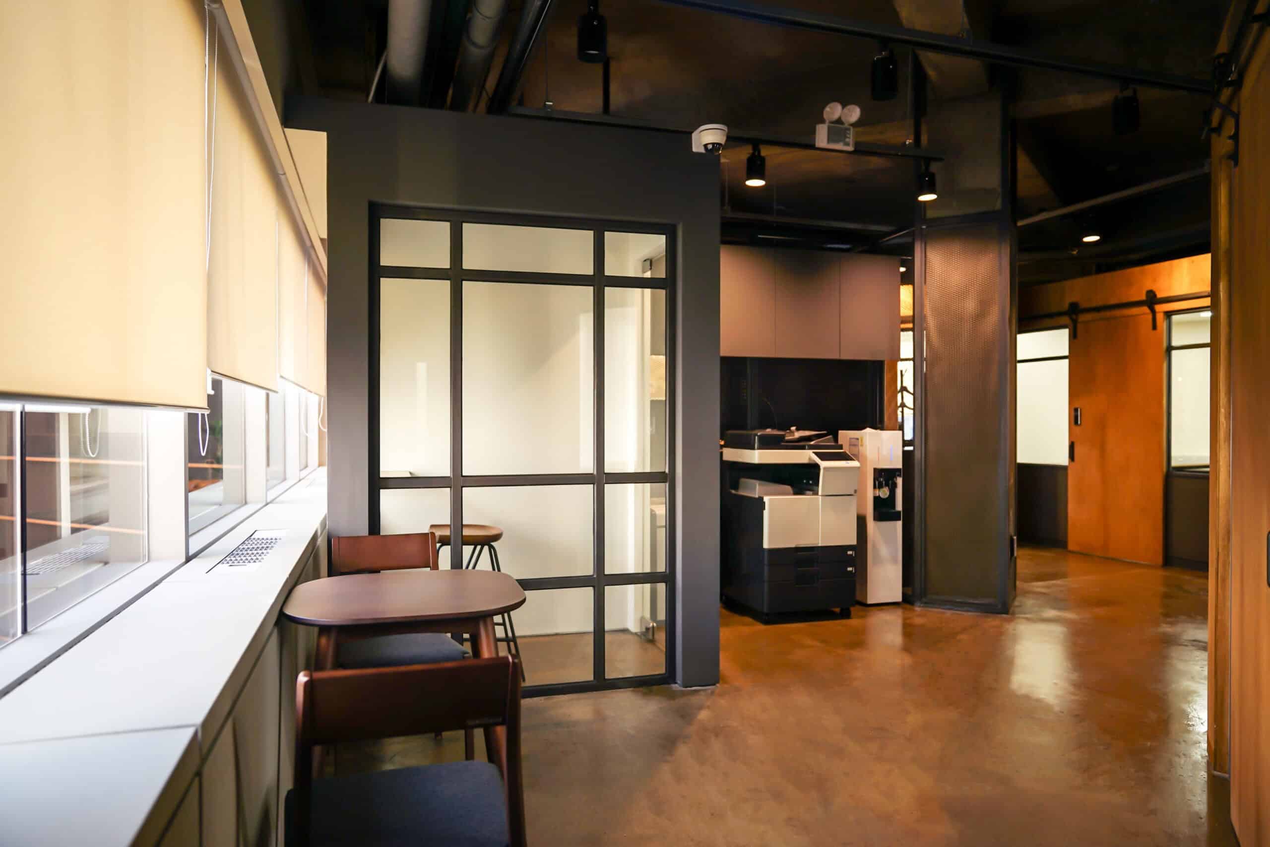 Contemporary office space with seating area and glass partition.