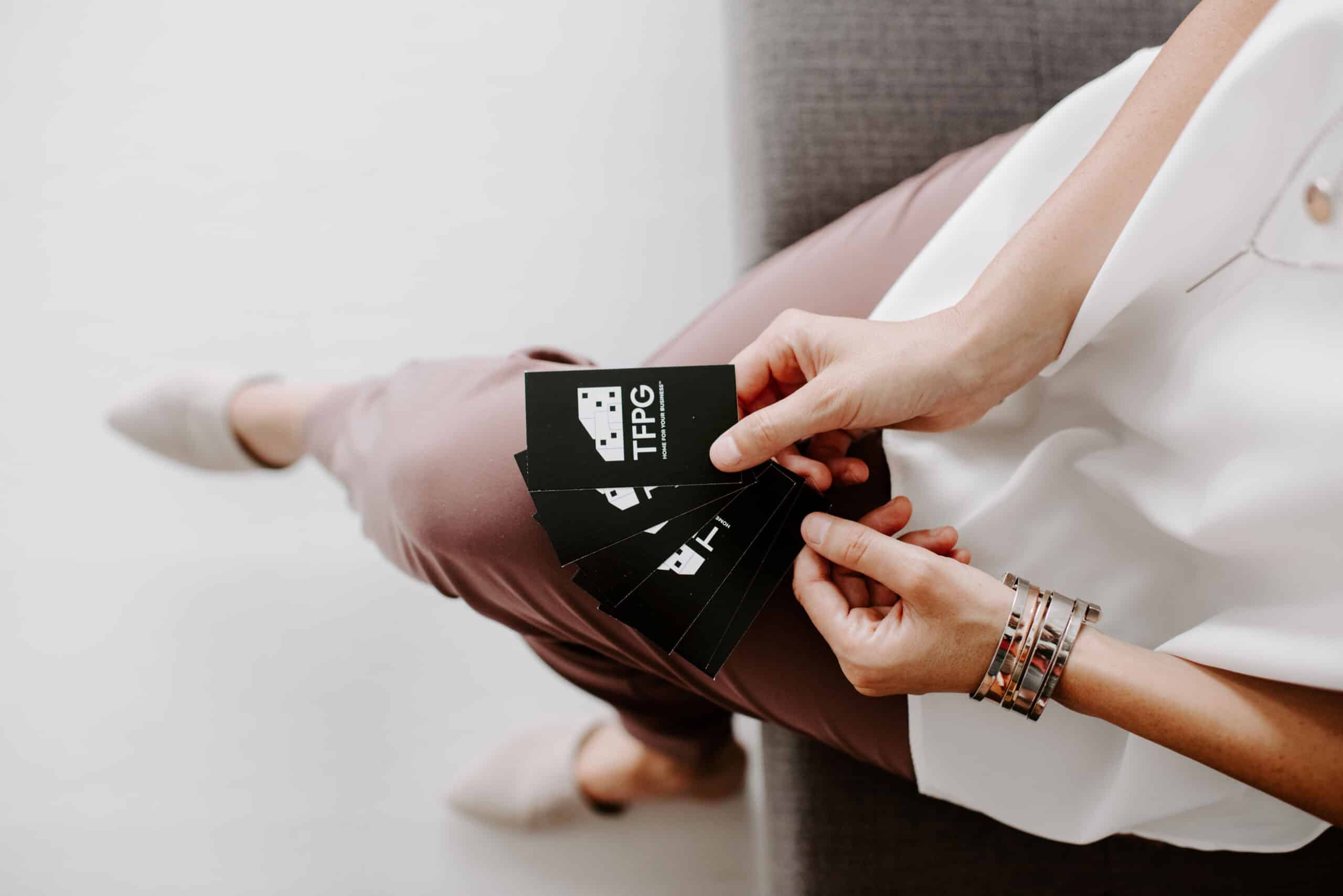 Person holding The Focal Point Group business cards in hand.