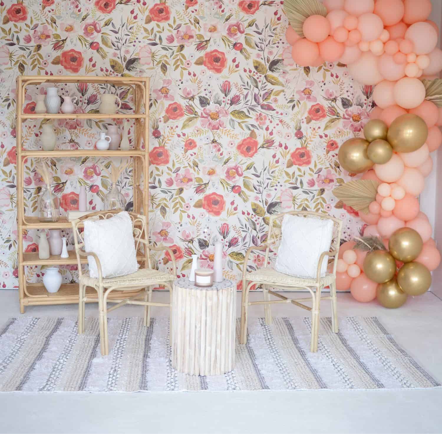 Chic floral wallpaper with balloon decor and cozy seating area.