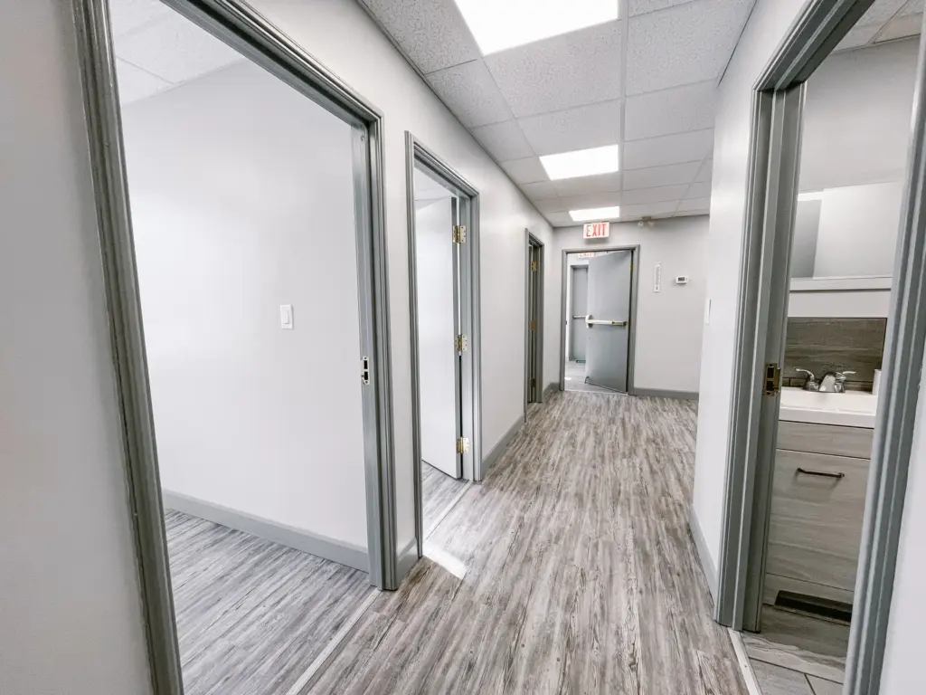 Corridor with private rooms and sink area in Suite 106B at 353 St. Paul Avenue, Brantford.