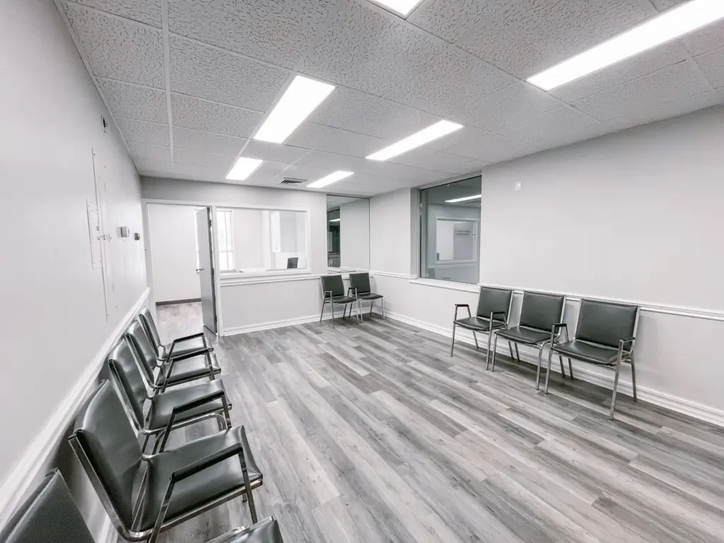Waiting room with wood-look flooring and reception window in Suite 205A at 353 St. Paul Avenue, Brantford.