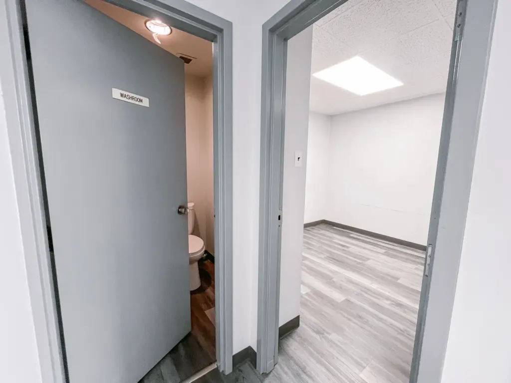 Washroom entrance beside a private clinical room in Suite 205A at 353 St. Paul Avenue, Brantford.