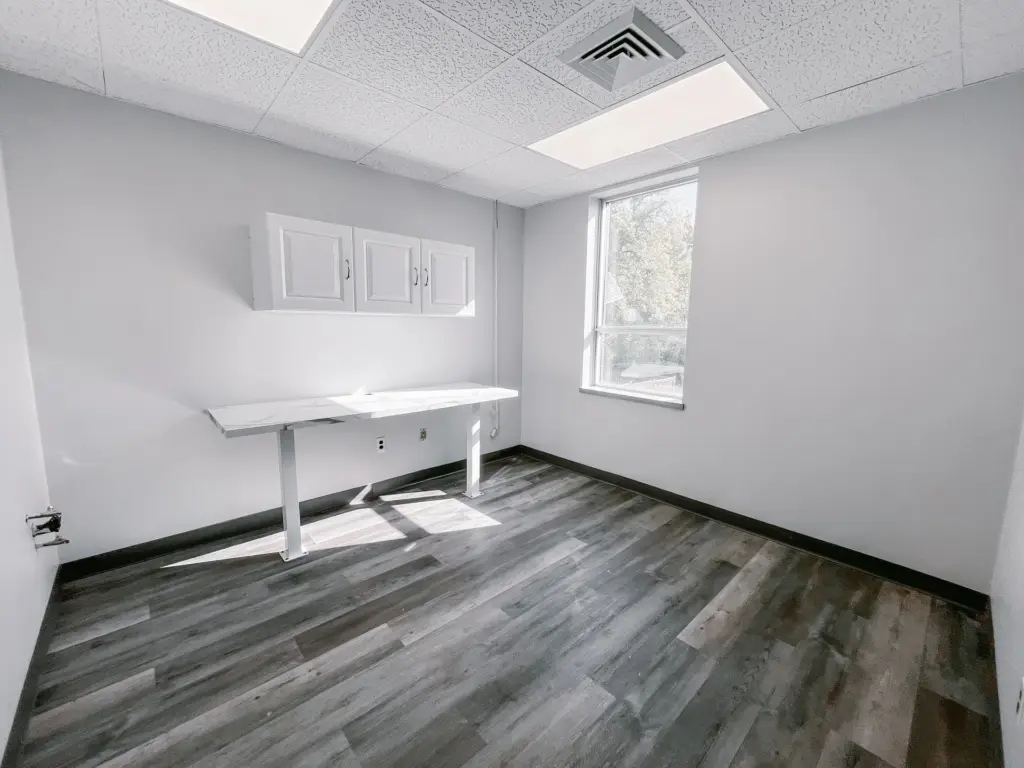 Windowed clinical room with cabinetry and wood-look flooring in Suite 205A at 353 St. Paul Avenue, Brantford.